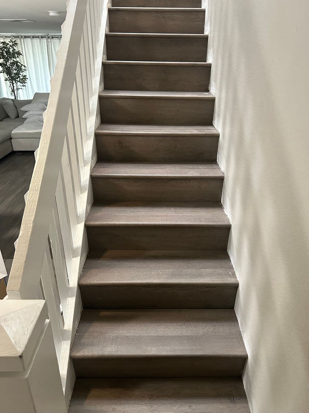 Modern wooden staircase leading to a bright, open living space.